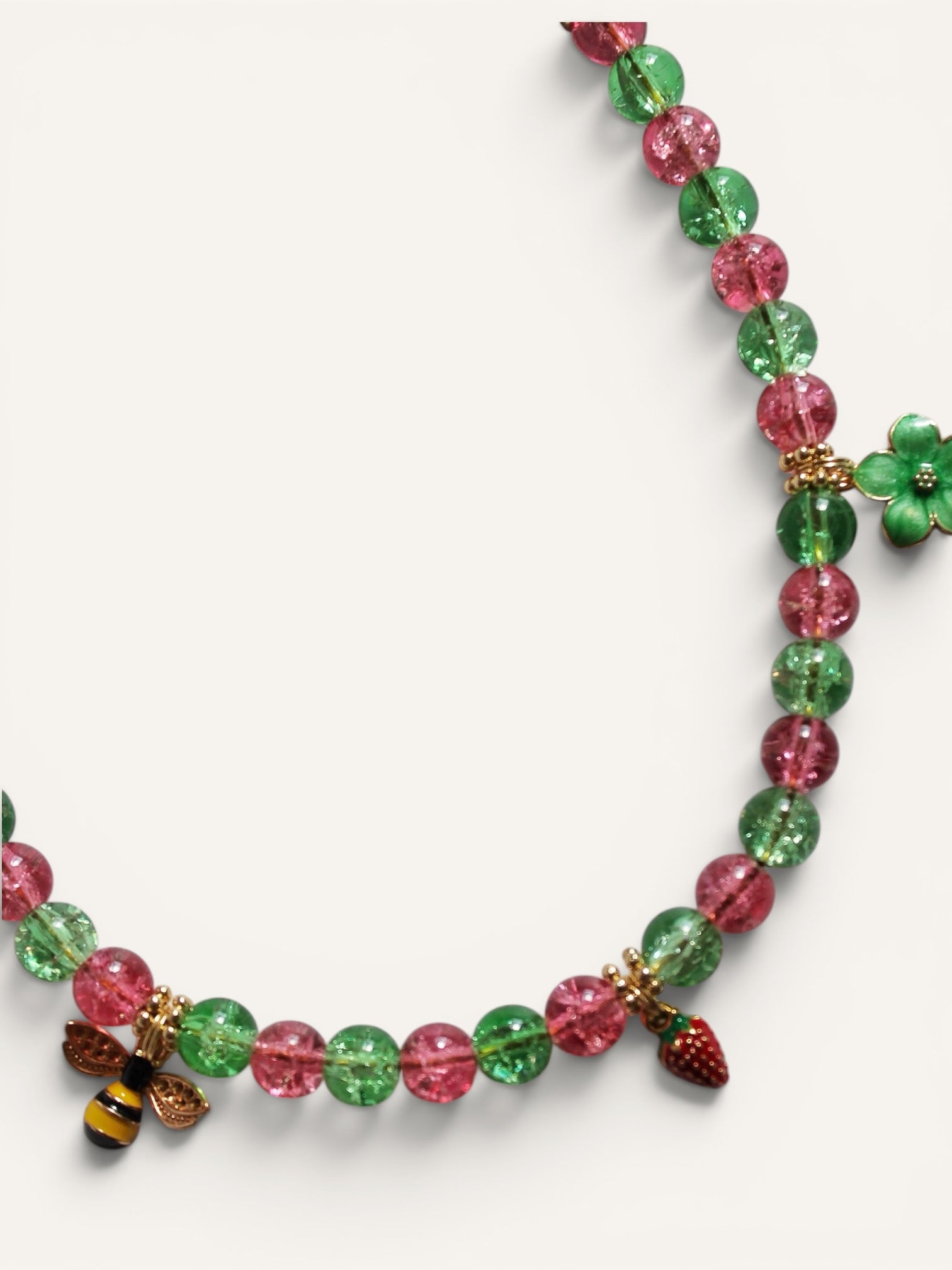 Détail de l'abeille, de la fraise et de la fleur du collier Bee Happy