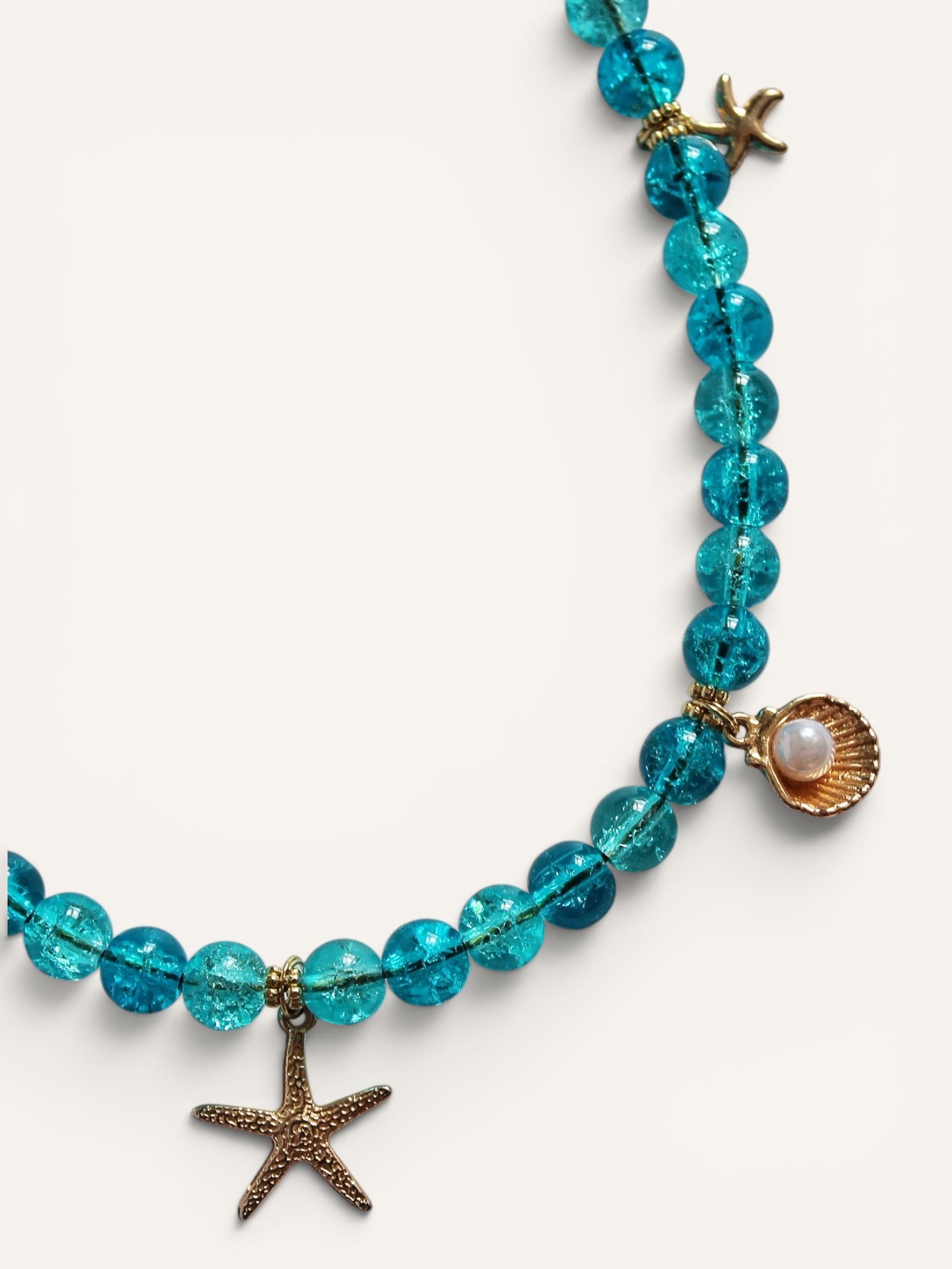 Détail du coquillage nacré et de l'étoile de mer du collier Calanque