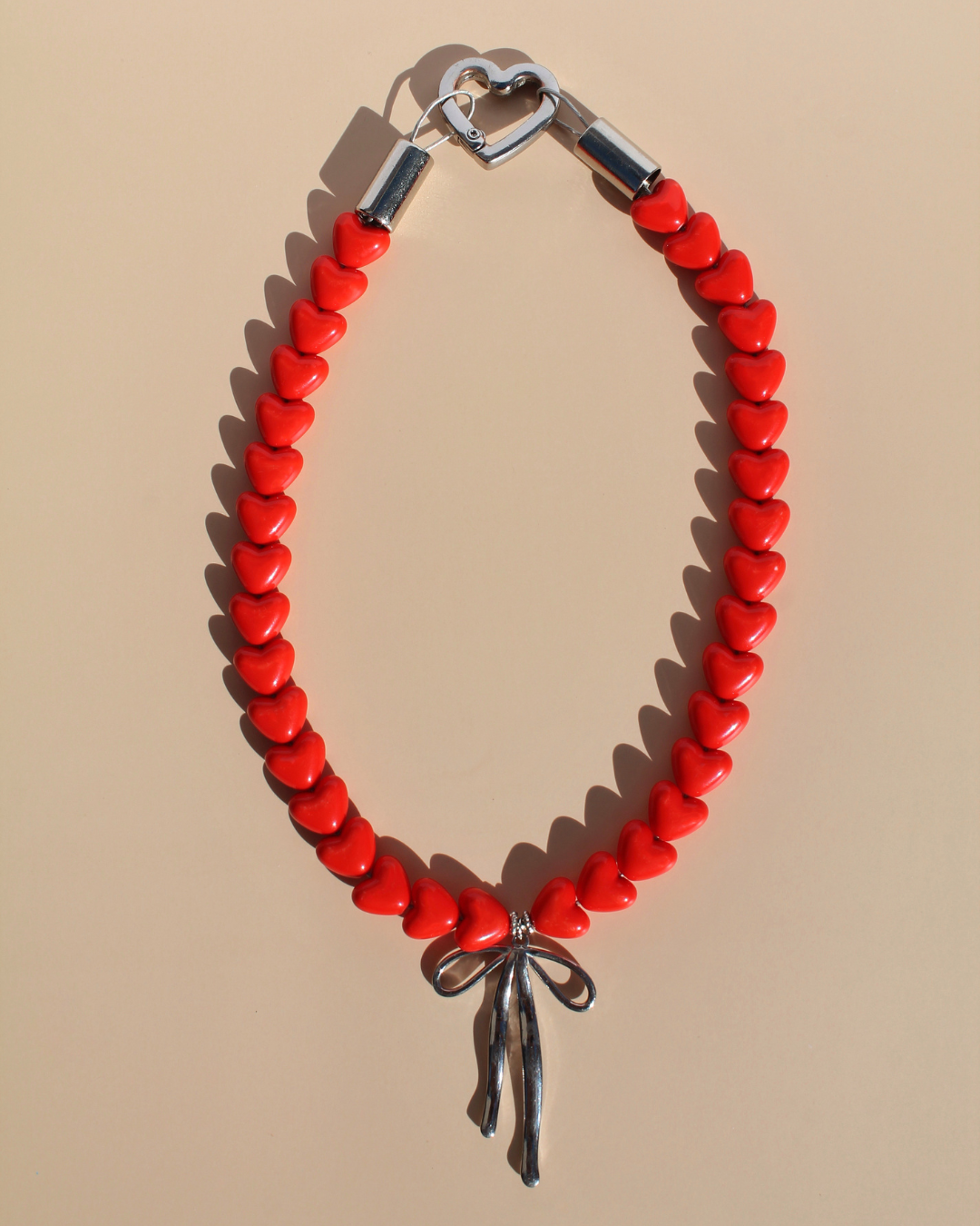 Collier pour chien en perles cœurs rouges avec fermoir cœur argenté et pendentif nœud – Zag & Wag