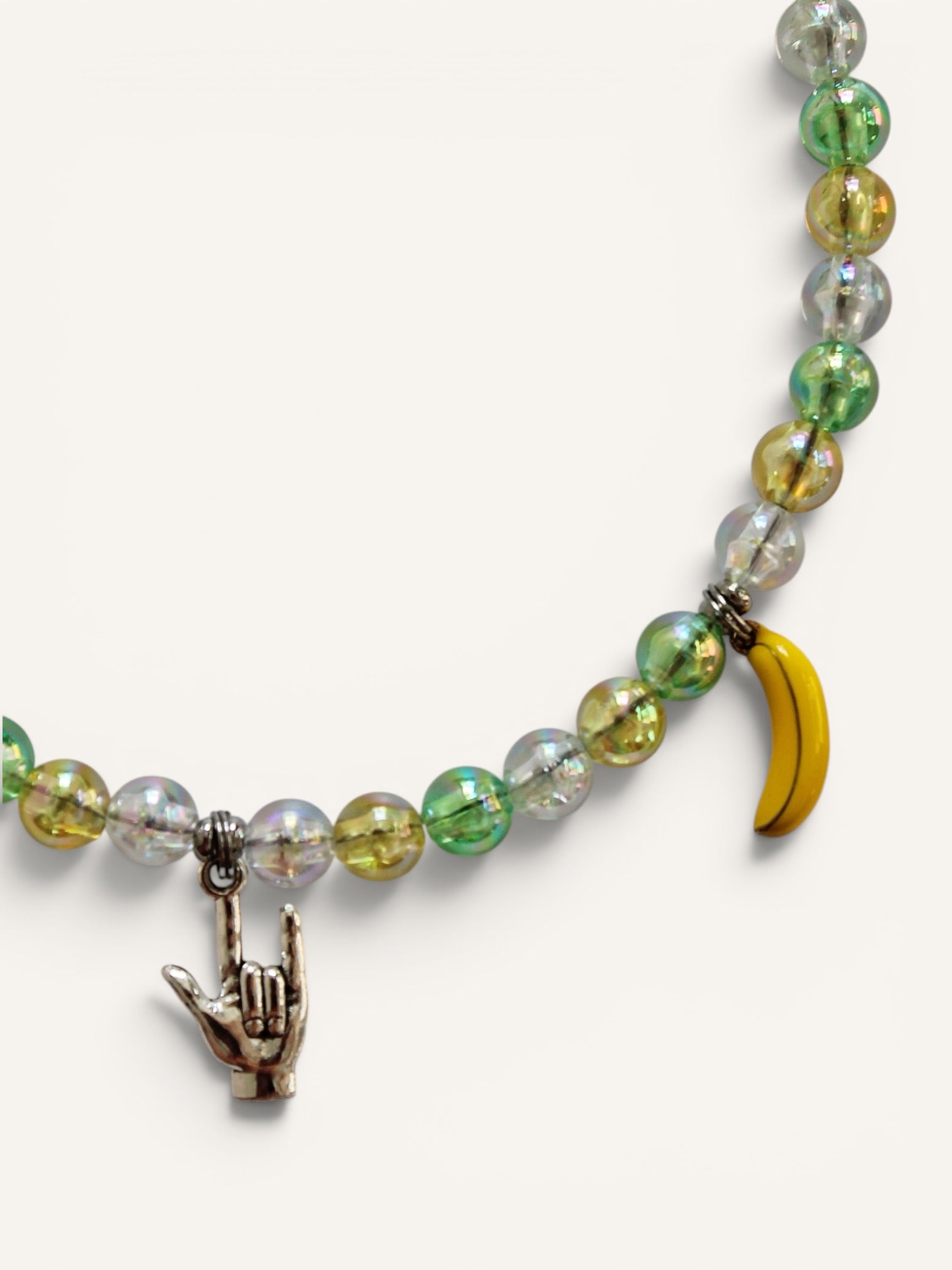 Détail des charms citron, banane et signe rock du collier Dolce Banana